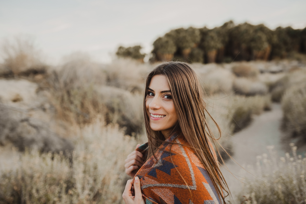 Pretty boho woman with windy hair in the desert nature